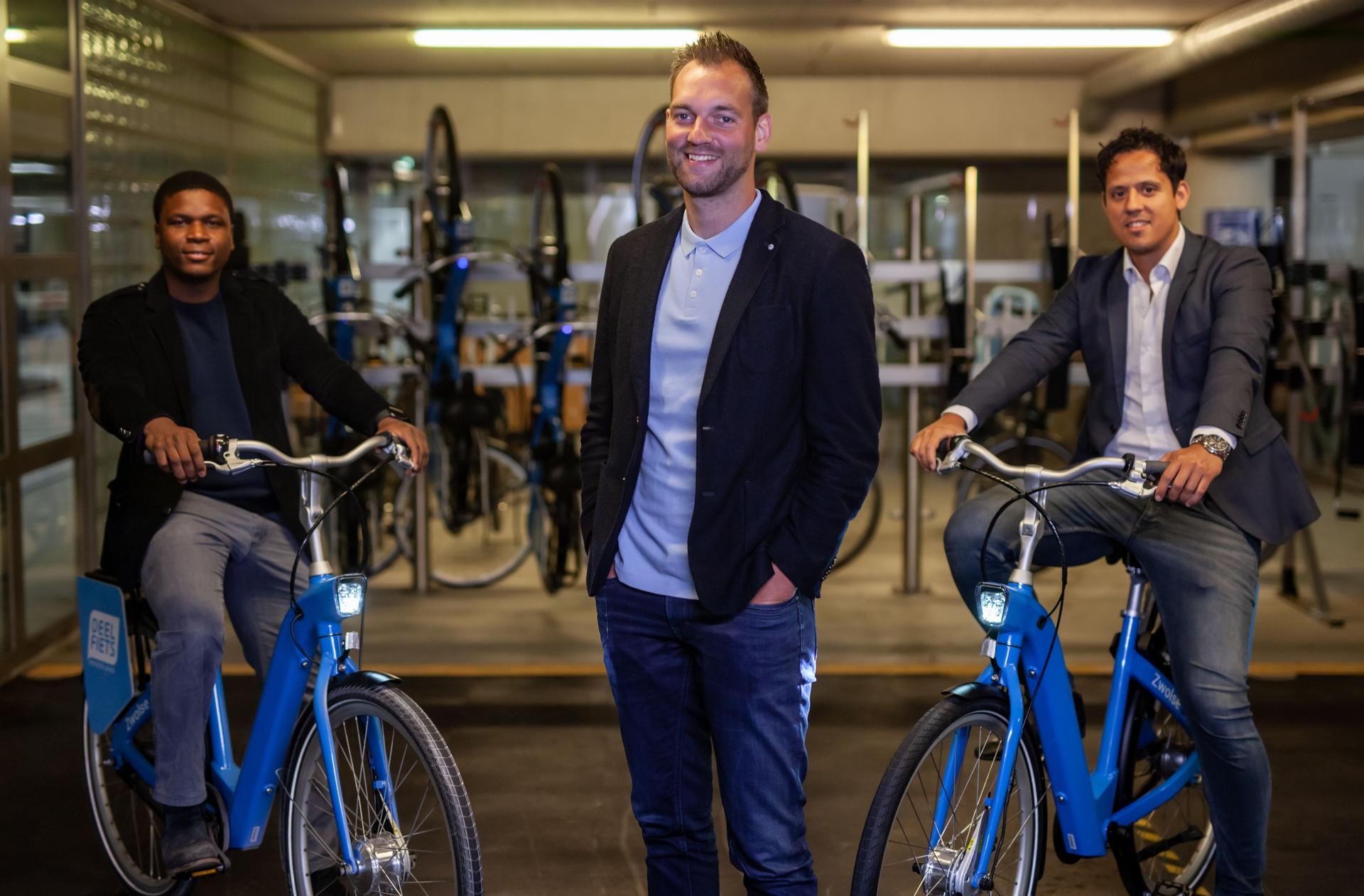 Michael Wolf samen met eigenaar Oumar Sylla en marketingsmanager Fikret Akin bij een droppoint van Deelfiets Nederland